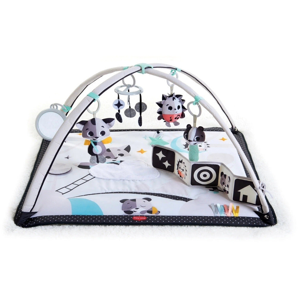 Tiny Love Magical Tales Black & White Gymini play gym with arched frame and hanging plush toys over a soft mat.
