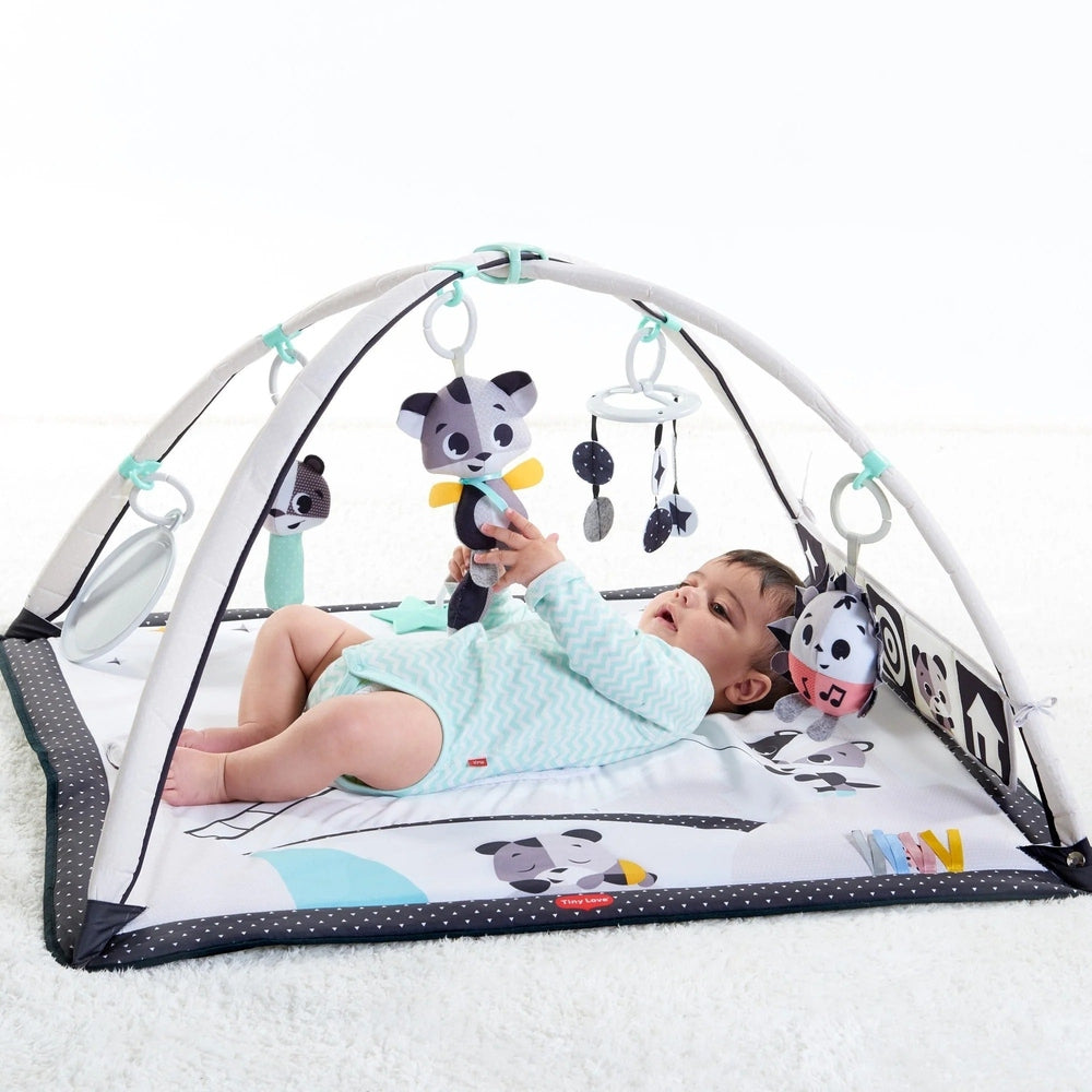 Tiny Love Magical Tales Black & White Gymini play mat: baby lying beneath the arched gym with hanging panda toys.