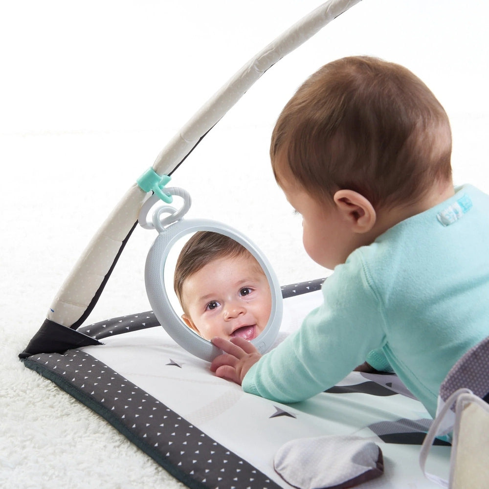 Tiny Love Magical Tales Black & White Gymini play gym; baby on a patterned mat gazes into the round mirror.
