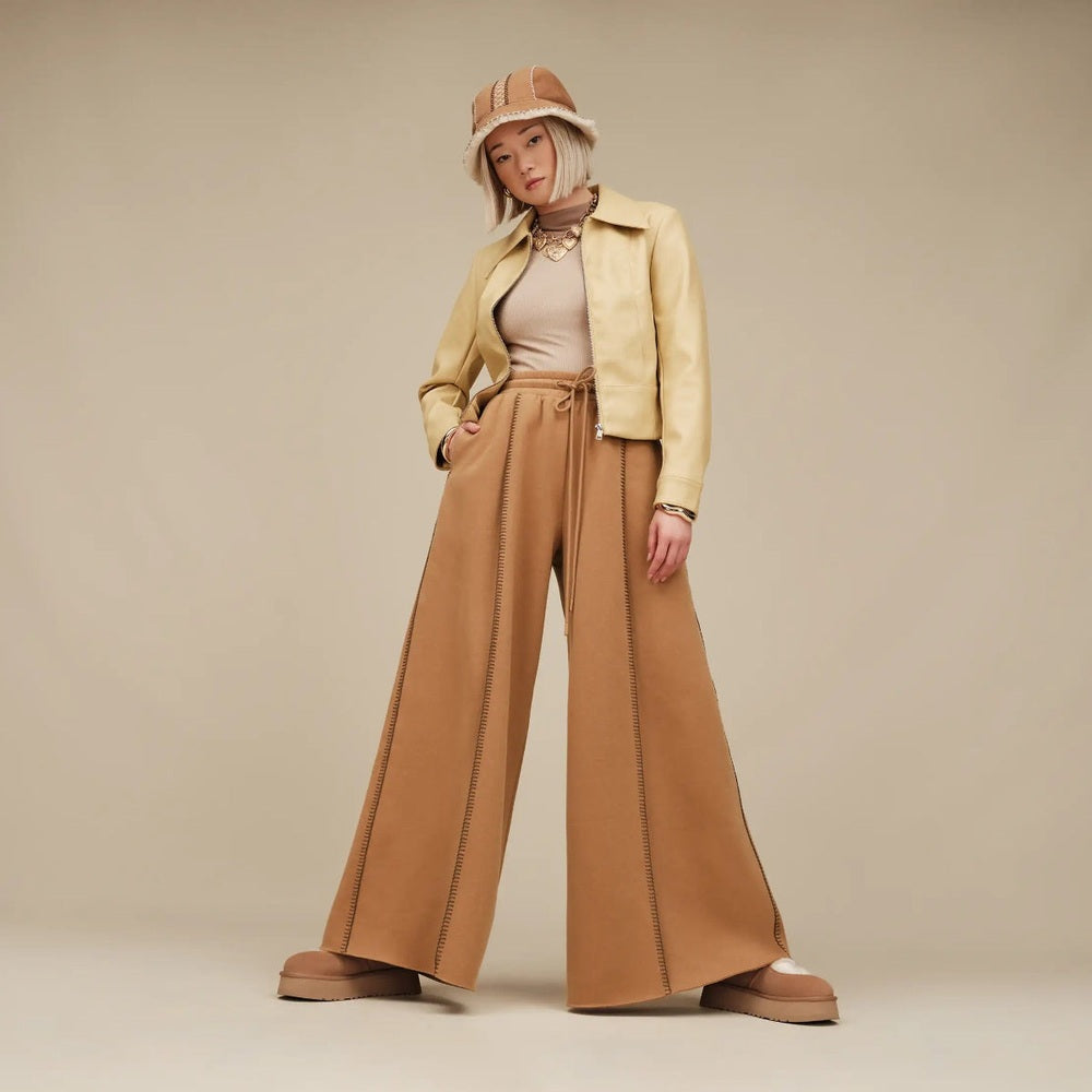 UGG Women's Bea Mary Jane Chestnut sandals on a model in an earth-toned outfit with wide-leg pants and a beige jacket.