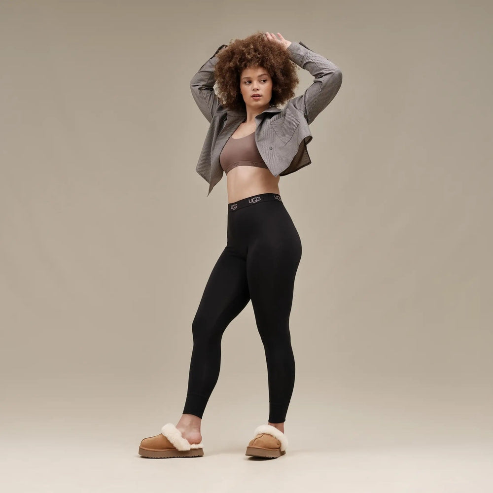 UGG Women's Disquette Chestnut slippers worn by a model in black leggings and a gray jacket, fur-lined tan slides.