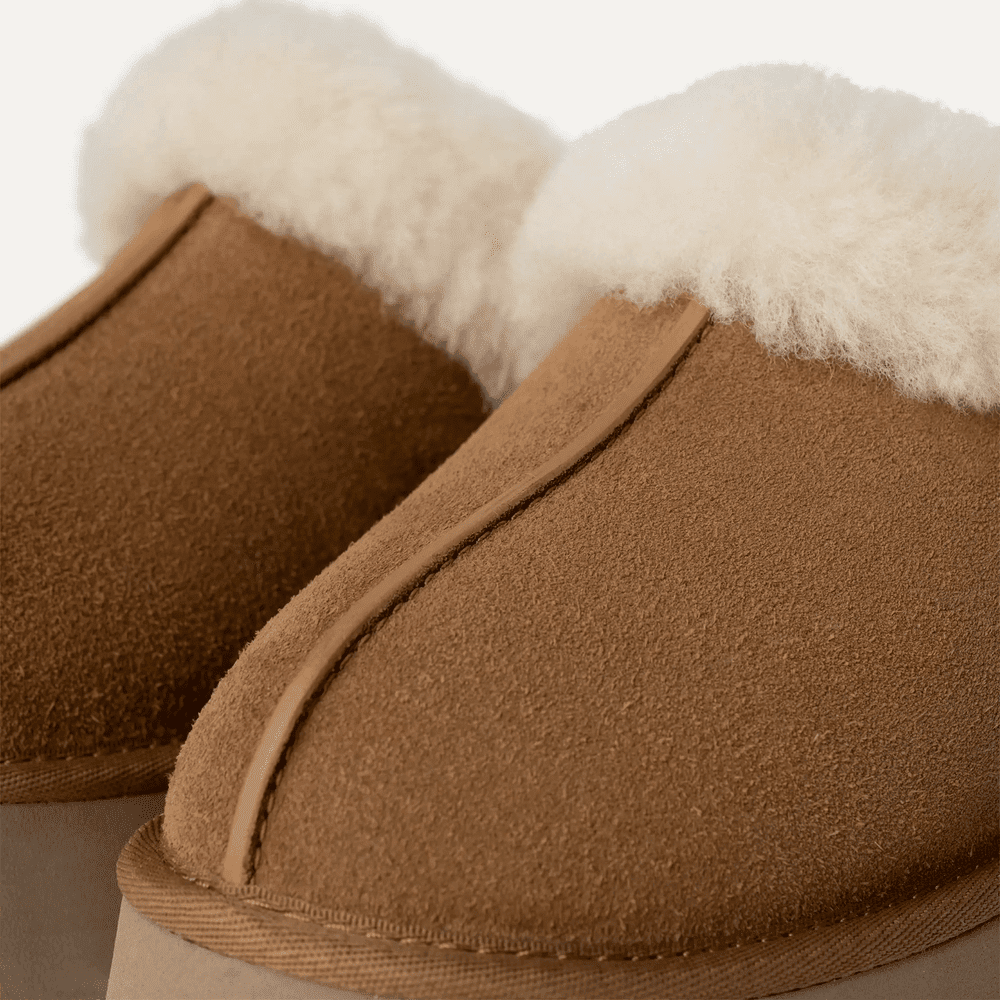 UGG Women's Disquette Chestnut suede slippers with white shearling lining, showcasing plush warmth at the opening.