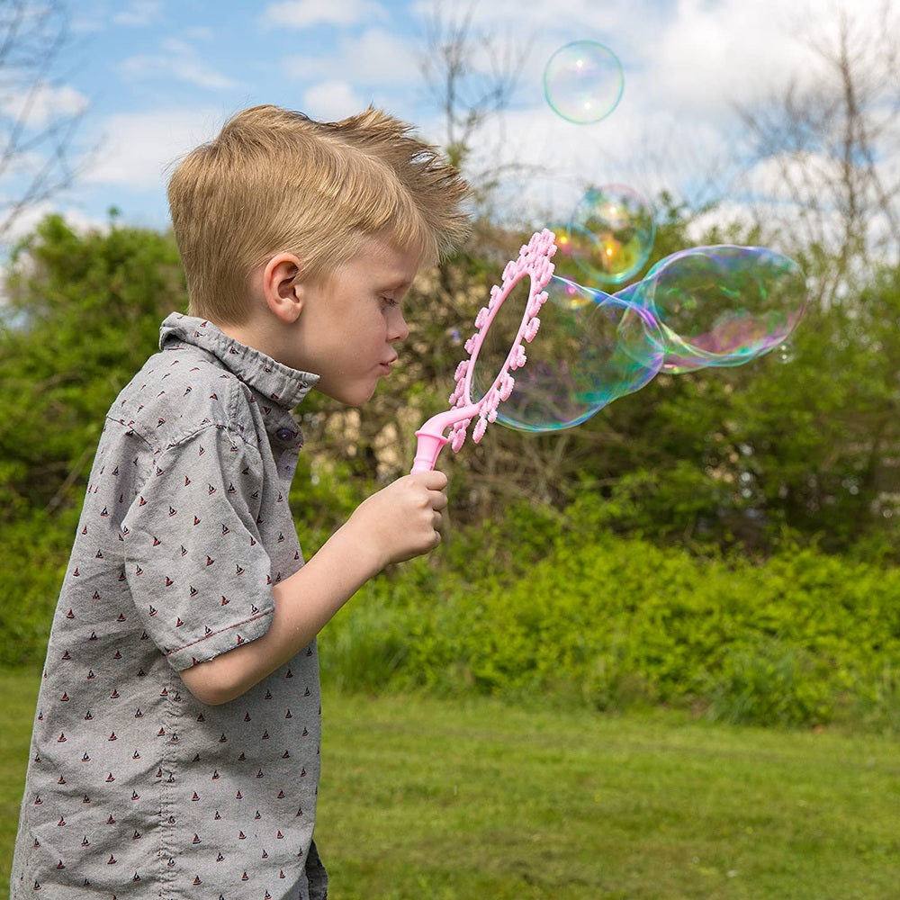 Uncle Bubble Fun Fantasy Wand 4 oz pink bubble wand held by child outdoors blowing bubbles