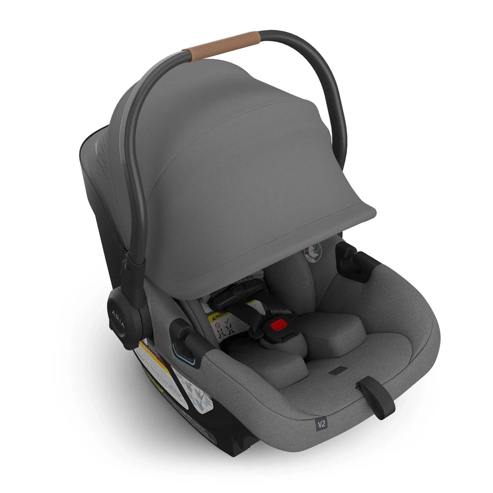 Uppababy Aria V2 Car Seat in Grey with tan leather-wrapped handle and extended canopy.