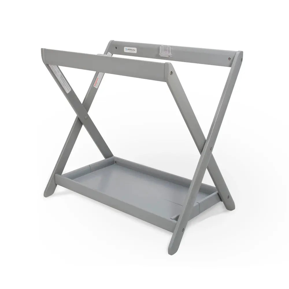 UPPAbaby Bassinet Stand in gray metal shows sturdy X-frame and built-in lower storage tray.
