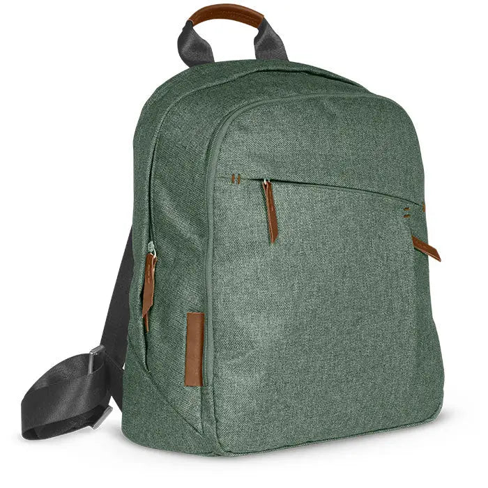 Uppababy Changing Backpack in green with brown leather accents, showing front zip pocket and top grab handle.