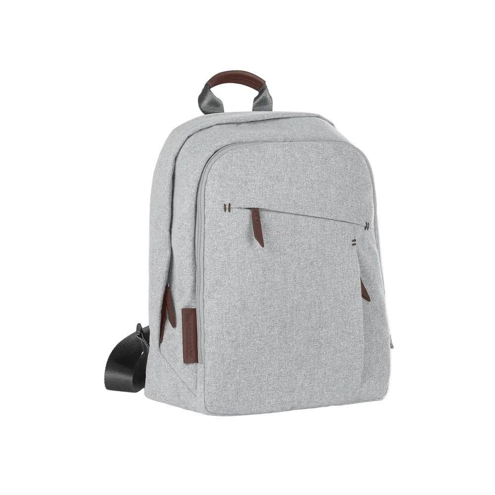 UPPABABY Changing Backpack in heather gray with brown accents, shown with front zip pockets and sturdy top handle.