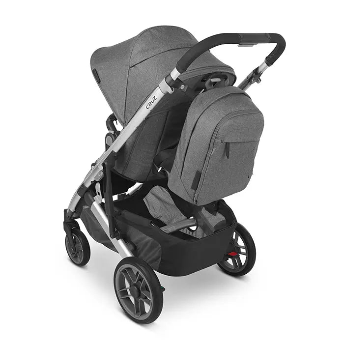 Uppababy Changing Backpack in grey clipped to a Cruz stroller, with multiple pockets visible.