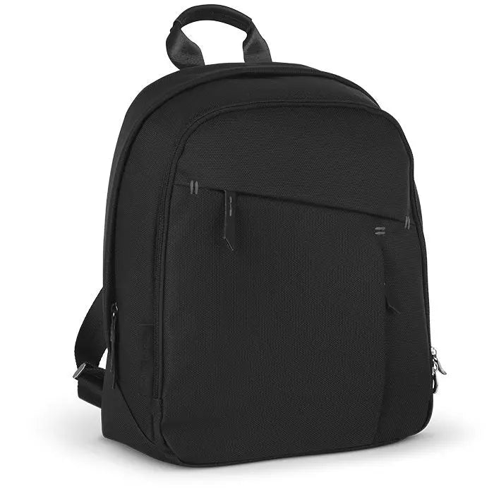 Uppababy Changing Backpack black sits upright on a surface, showcasing front zip pocket and top carry handle.