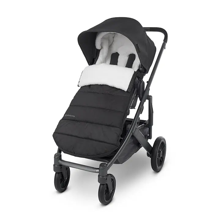Uppababy Cozy Ganoosh stroller footmuff in black with white faux fur lining, shown fitted over a stroller seat for warmth.