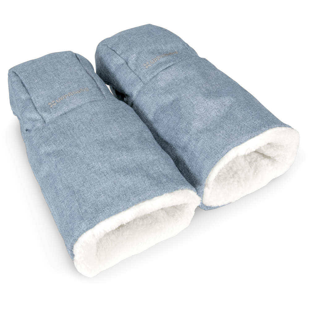 UPPABABY Cozy Handmuffs blue denim with white sherpa lining shown clipped to a stroller handle for warm winter walks.