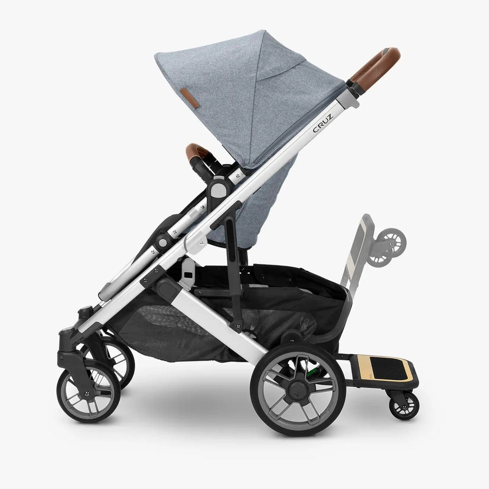 Uppababy Cruz V2 Piggyback Ride-Along Board attached to rear of stroller with black footboard and wood-accent platform
