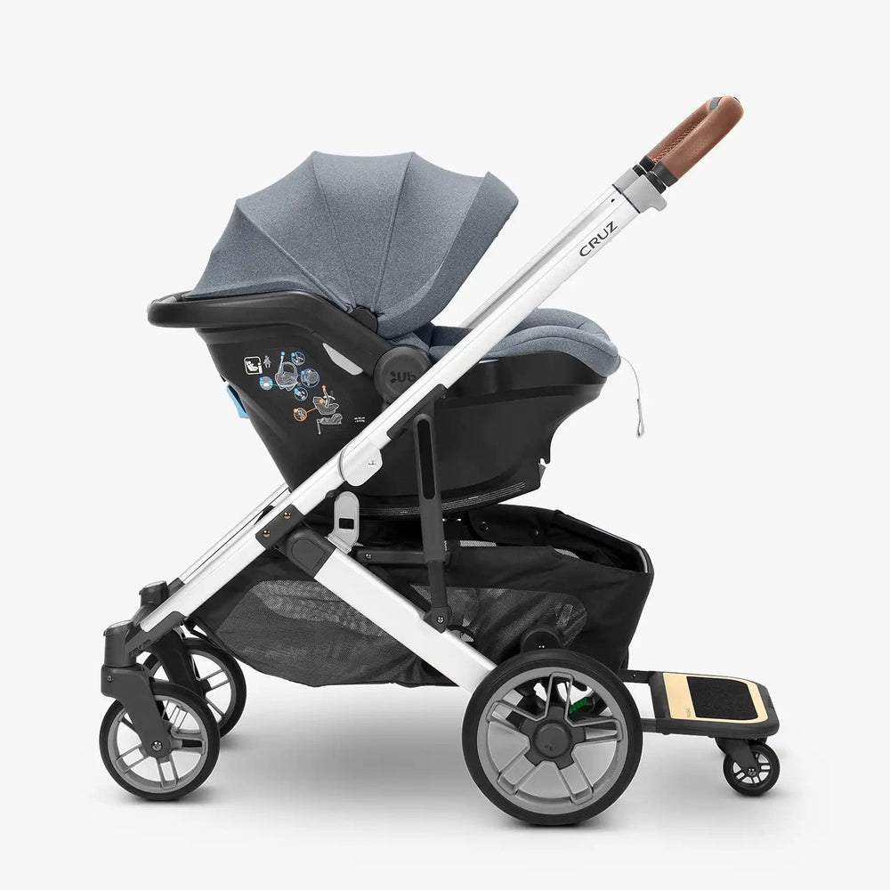UPPABABY Cruz V2 Piggyback Ride Along Board attached to stroller with gray seat and white frame