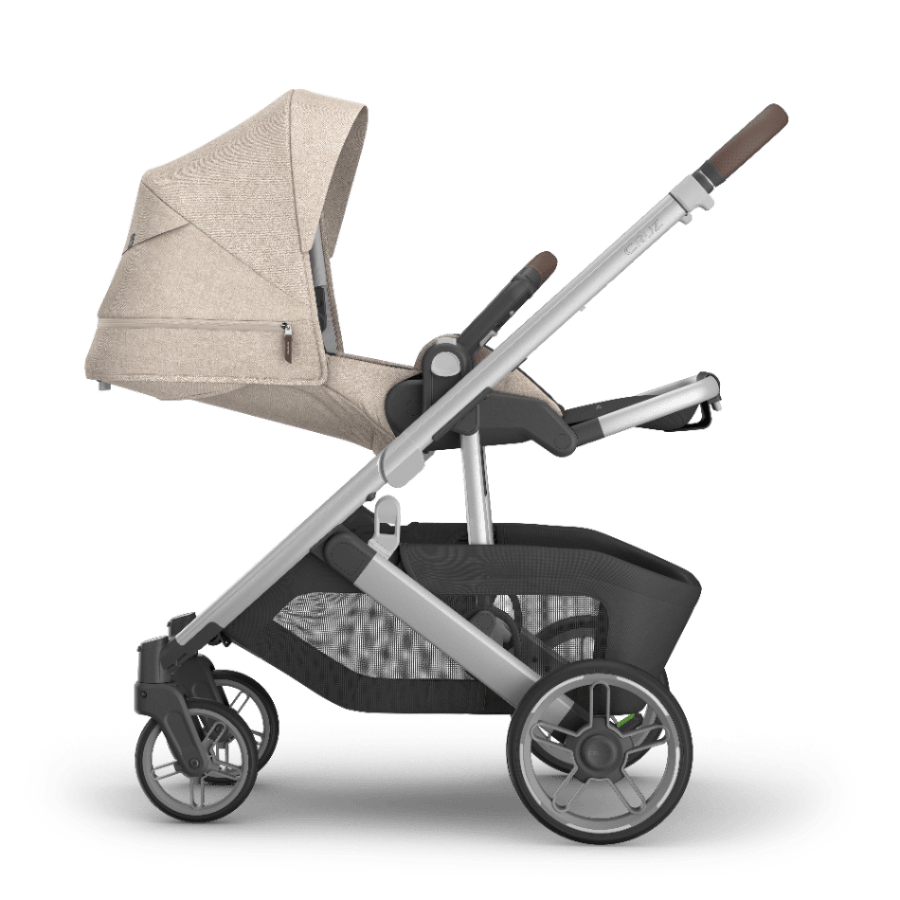 Uppababy Cruz V3 stroller with beige canopy, silver frame, black storage basket