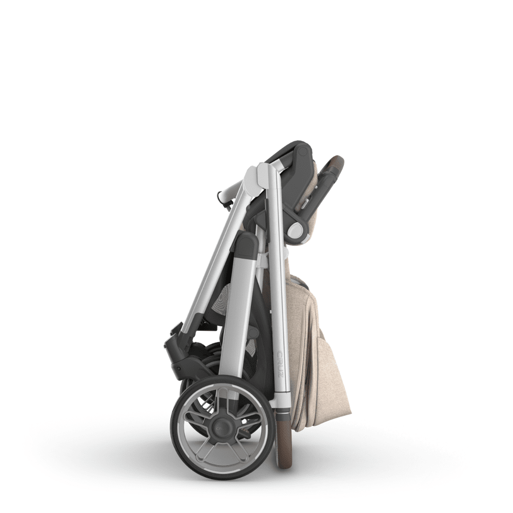 UPPAbaby Cruz V3 stroller folded in beige fabric with silver frame and large rear wheels