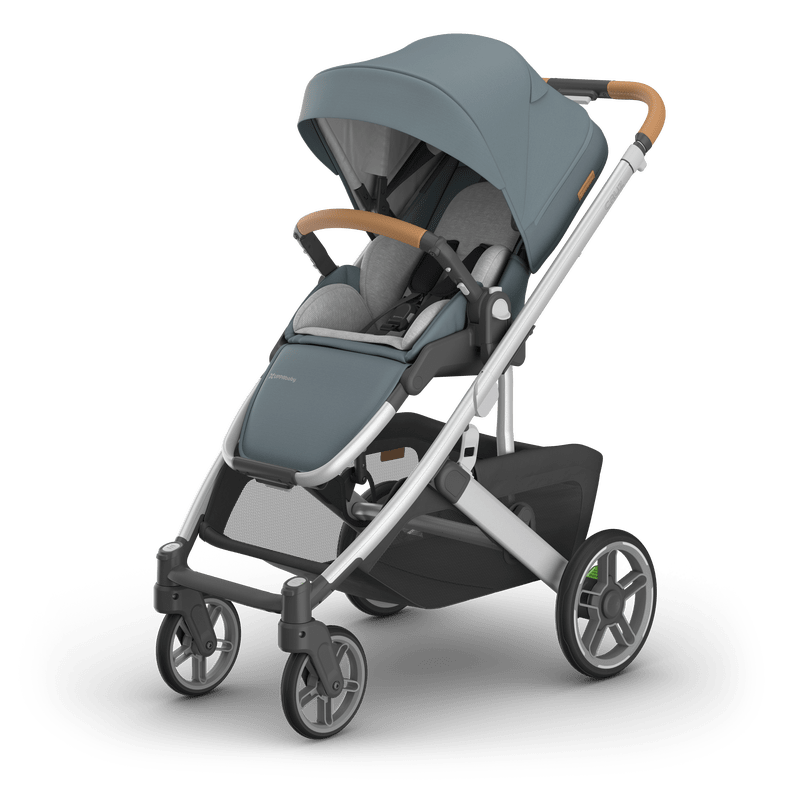 UPPAbaby Cruz V3 stroller in blue-gray fabric with brown leatherette handlebars and canopy