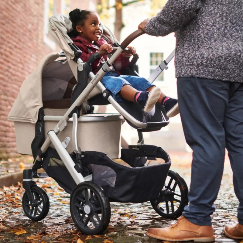 Uppababy Lower Adapters for Vista with child in rumble seat on stroller frame outdoors in fall