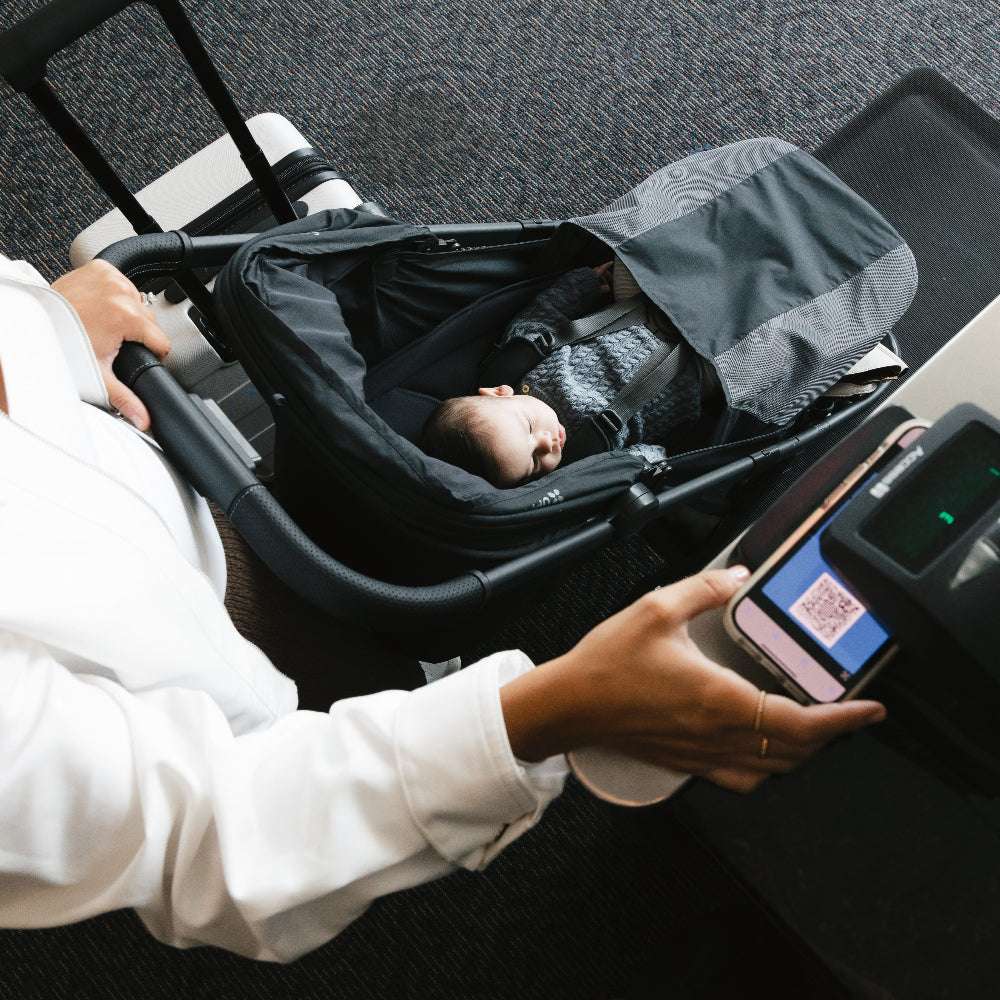 UPPABABY Minu V3 stroller in black with infant seated under canopy