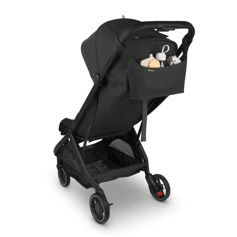 UPPABABY Minu V3 stroller in black with front organizer holding baby toys