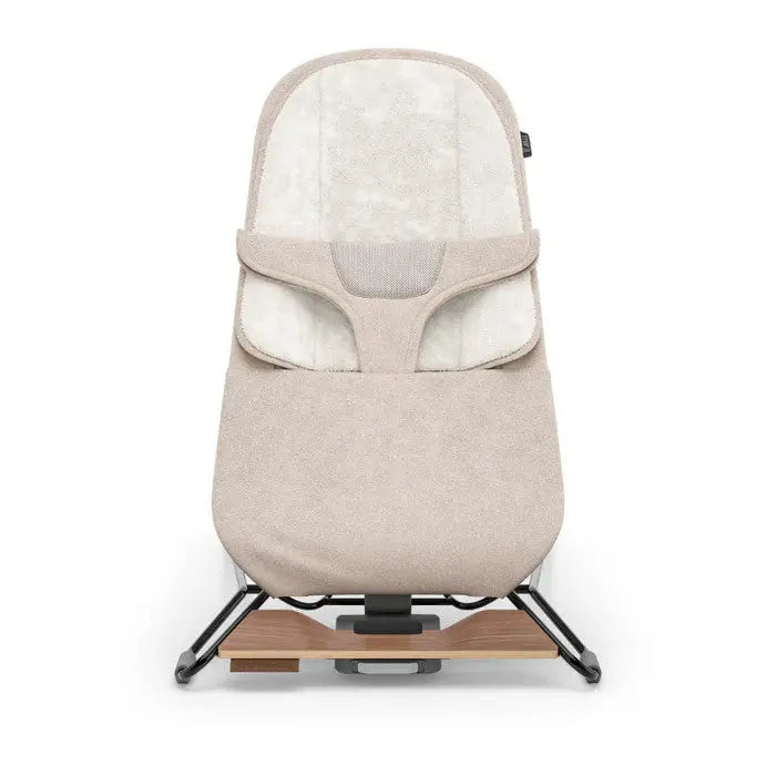 Uppababy Mira 2-in-1 bouncer and seat in beige fabric, securely mounted on a wooden base with rockers.