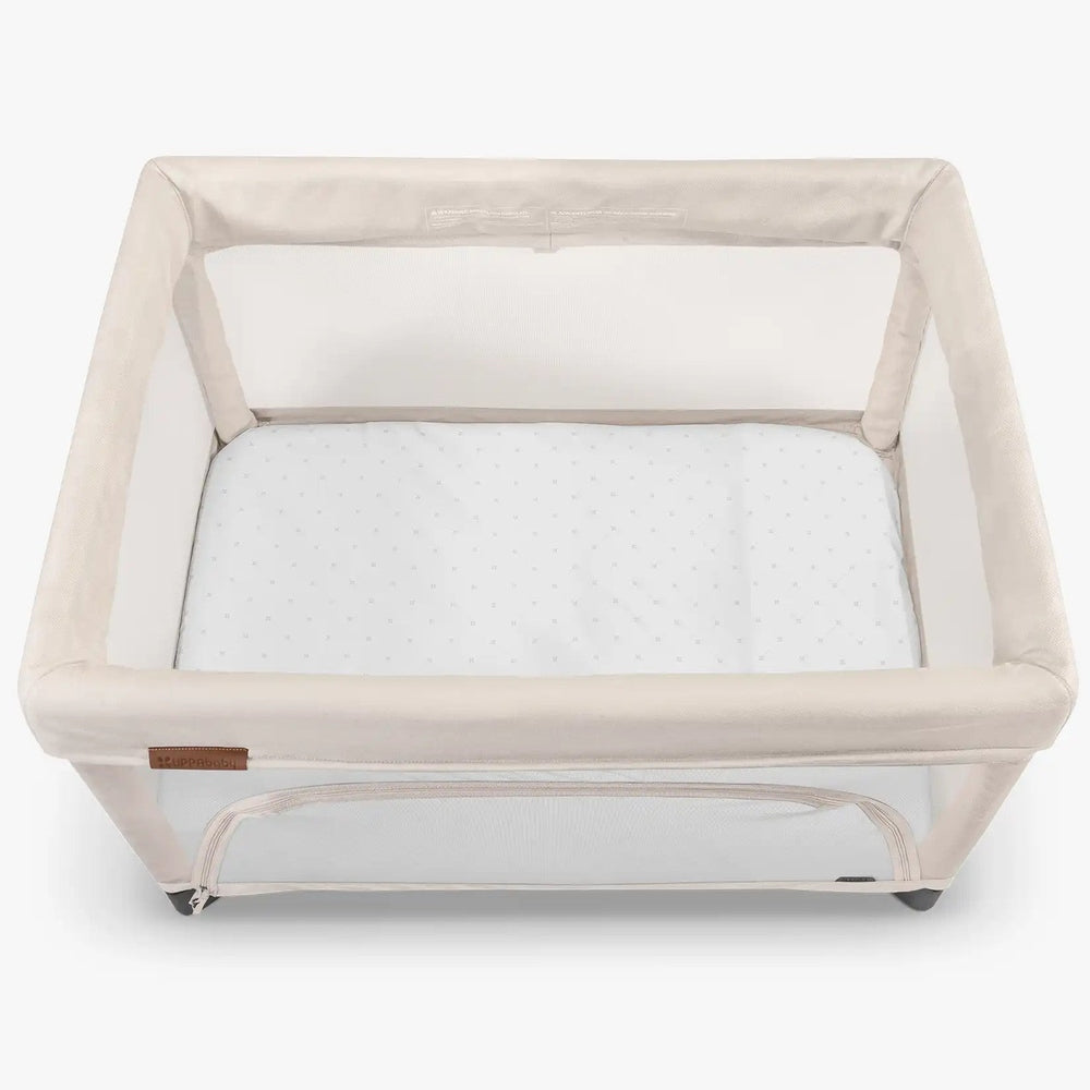 Uppababy Remi V1 waterproof bassinet mattress cover; beige frame with white dotted mattress