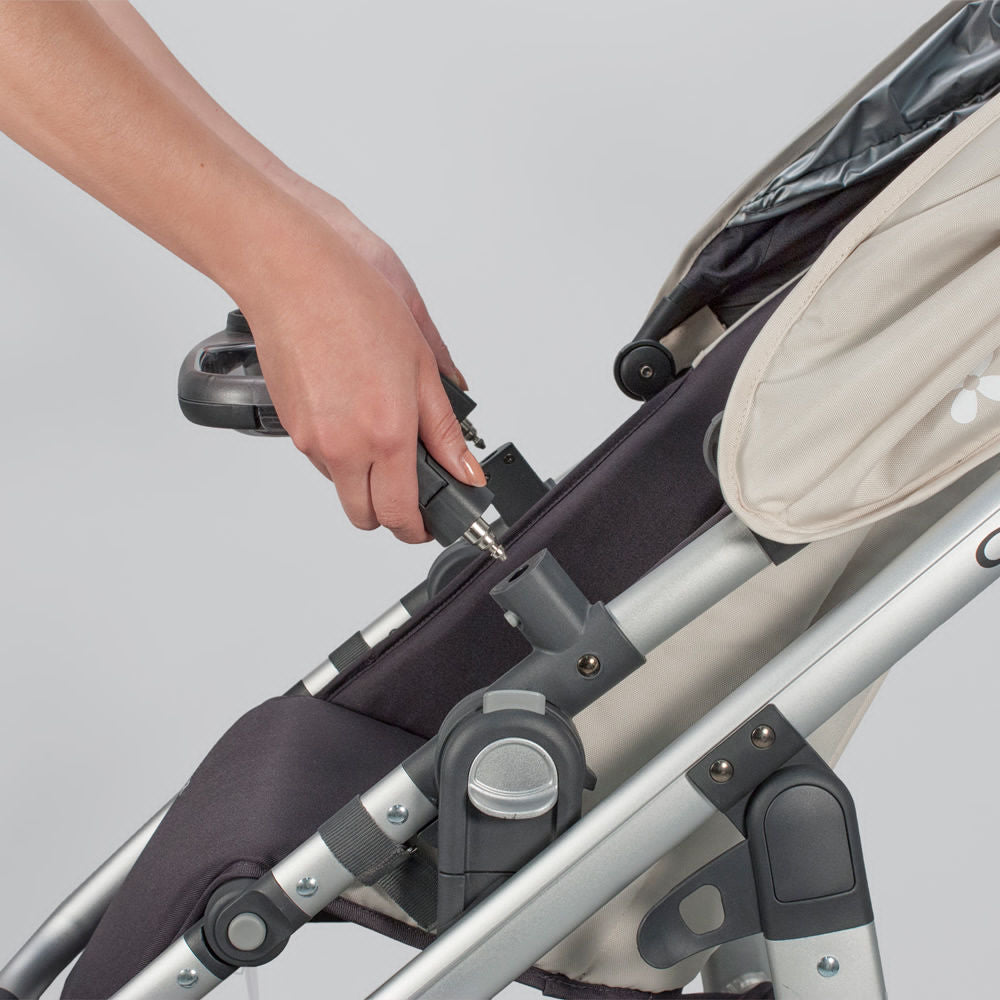 Uppababy Vista and Cruz Snack Tray being clipped onto a gray stroller frame.