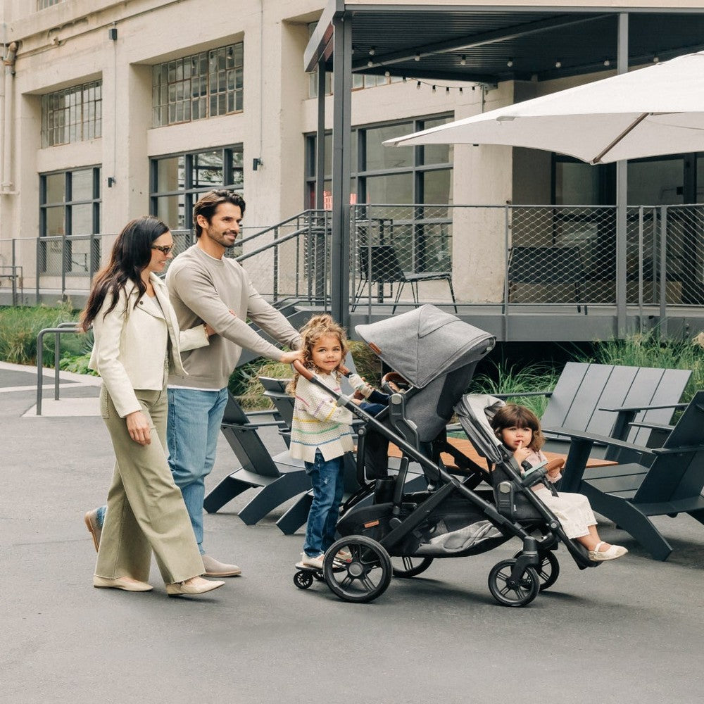 Family with two children using a stroller in an urban setting