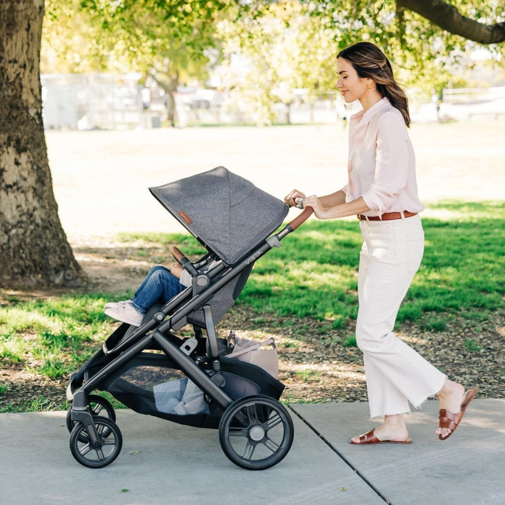 Woman pushing a stroller with a child in a park