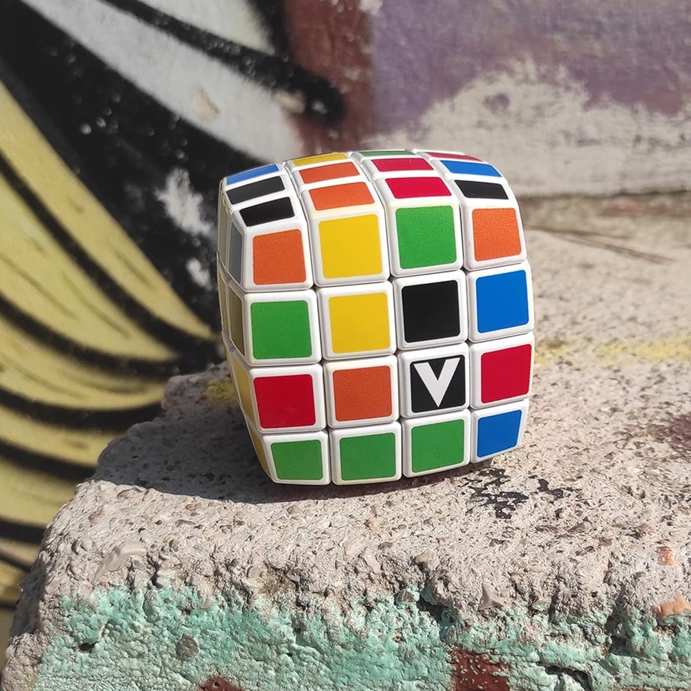 V-CUBE 4x4 curved color-matching puzzle with white frame and multicolor stickers on a concrete surface