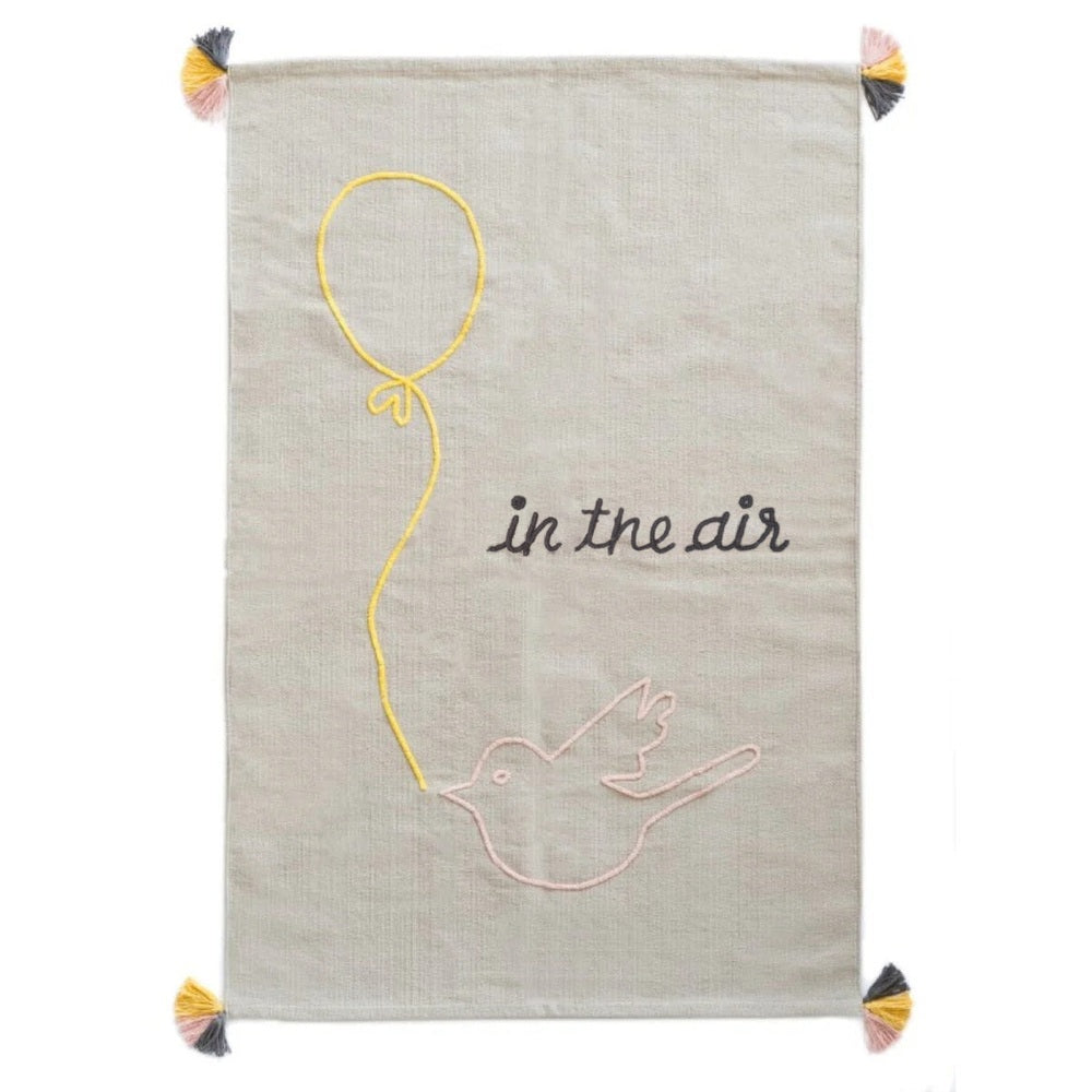 Varanassi hand-woven cotton rug In The Air with a yellow balloon string and pink bird on beige.