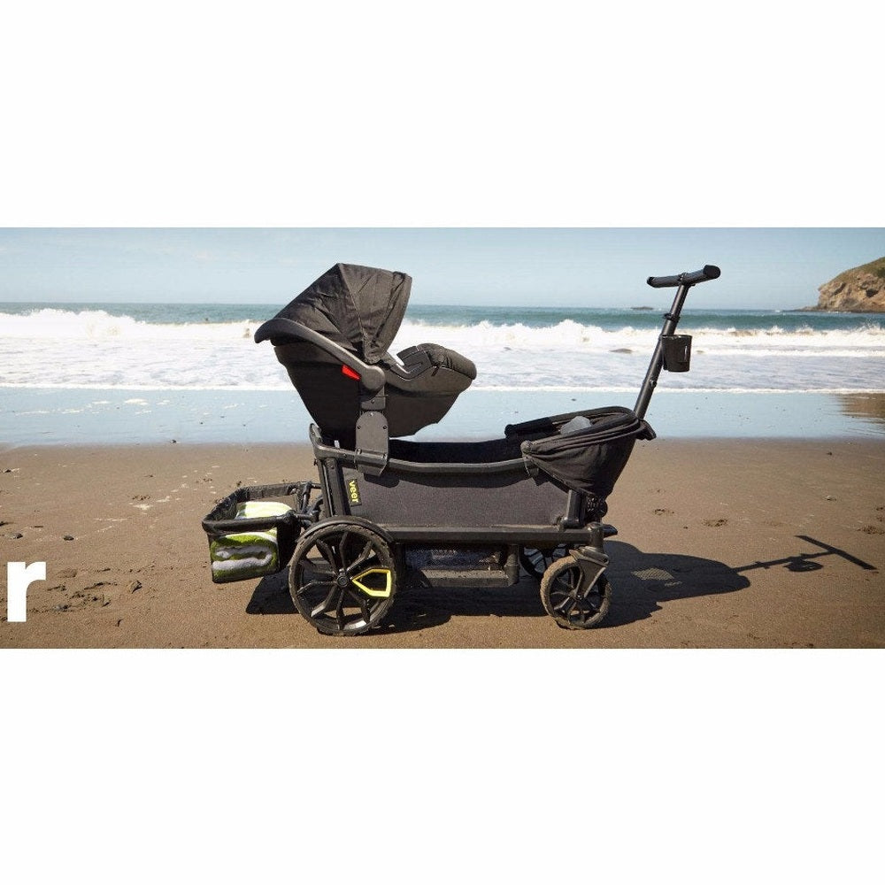 Veer All-Terrain Cruiser Wagon on a sandy beach with black frame and kid-friendly accessories