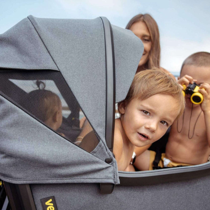 Veer All-Terrain Cruiser XL Wagon in gray fabric with mesh window; kids peeking inside.