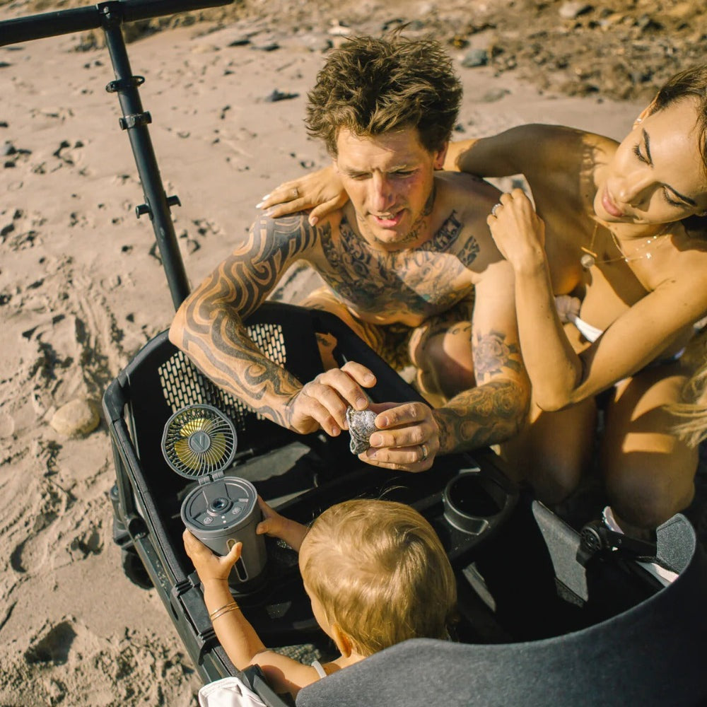 Veer Misting Fan portable handheld mister cooling a family on the beach