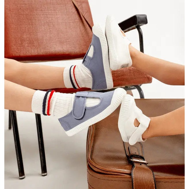 Victoria 1915 Sandal Dyed Canvas Straps Blanco; light blue-gray canvas, white sole, Velcro straps worn by a child.