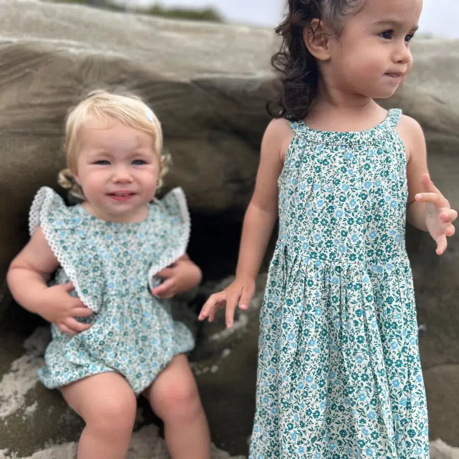 Vignette Poppy Bubble Teal Ditsy Floral baby outfits; two toddlers wear teal floral bubble romper and sleeveless dress.