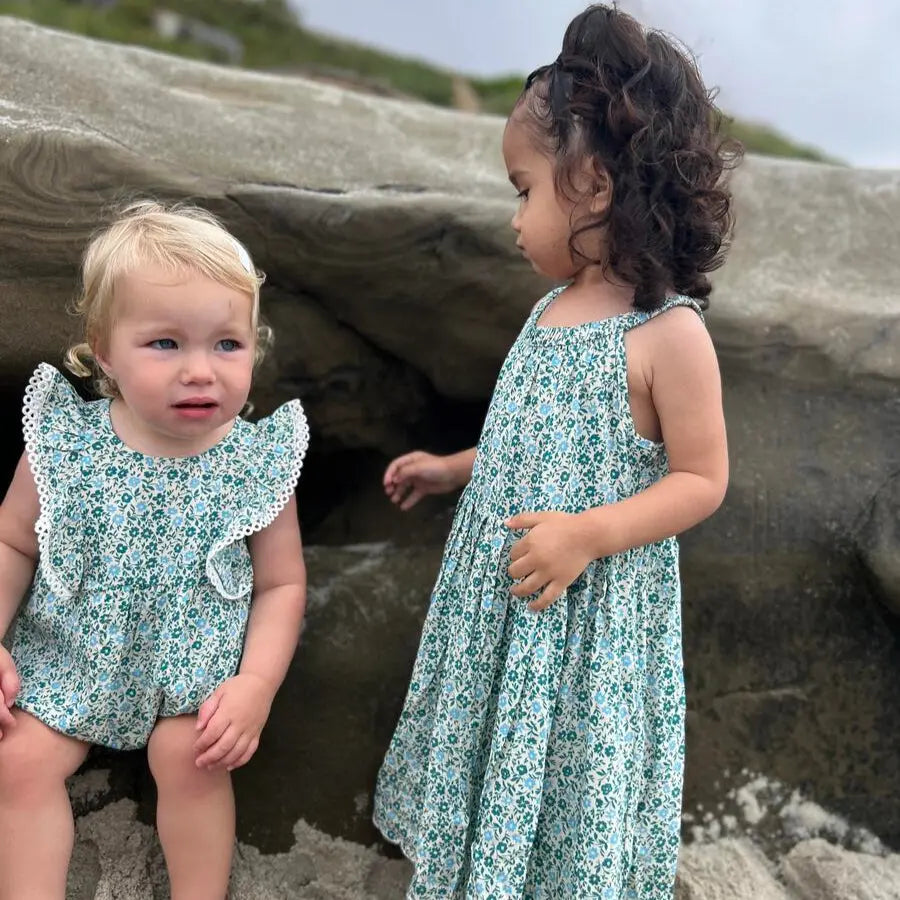 Vignette Poppy Bubble Teal Ditsy Floral baby outfits; two toddlers in teal floral dress and romper at the beach.