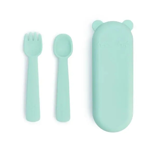 We Might Be Tiny Feedie Fork & Spoon Set in mint, laid out with a matching travel case for on-the-go feeding.