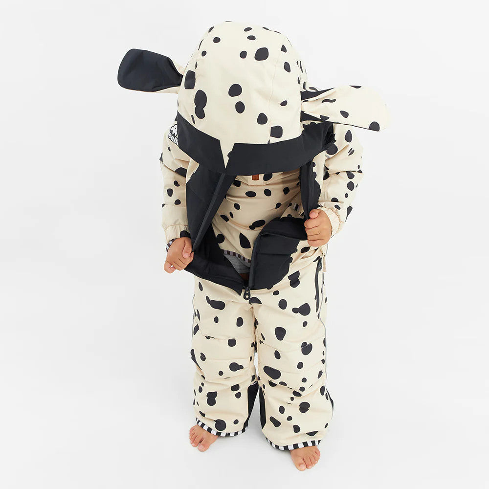 WEEDO Weedo Puppydo Snowsuit on a toddler in cream Dalmatian spots, hood up, with hands pulling the zipper open.
