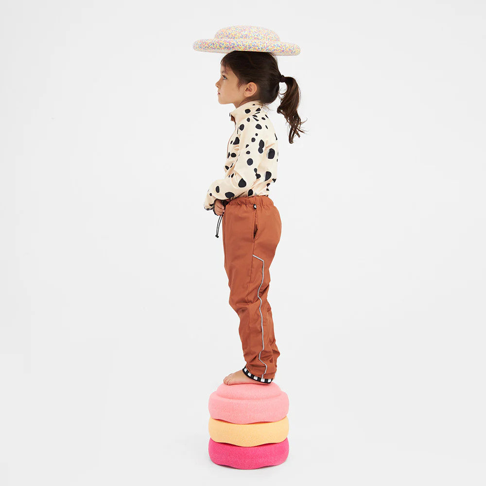 Weedo Puppydo Thermoshirt: cream polka-dot long-sleeve top with brown pants, child balanced on pastel cushions.