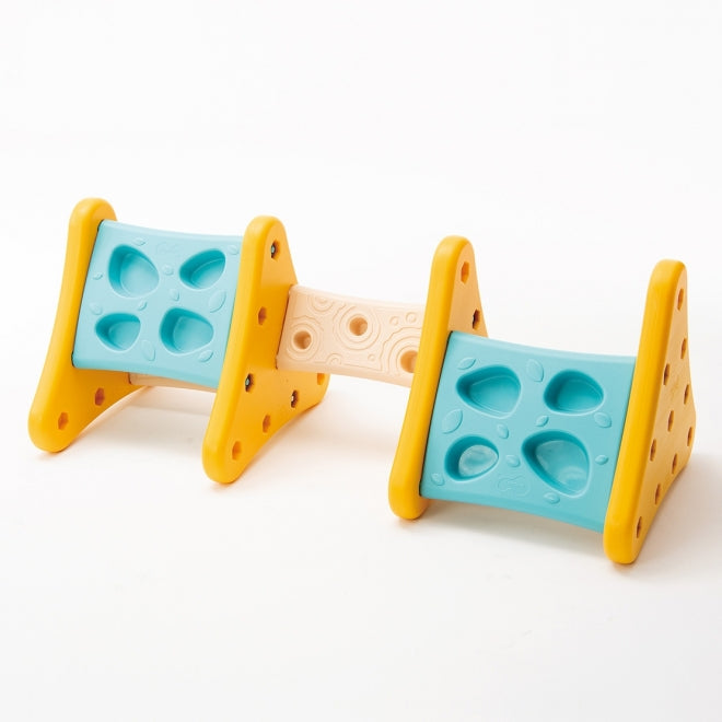 Weplay Over The Mountain climbing toy with yellow end frames, blue panels, and beige bridge.