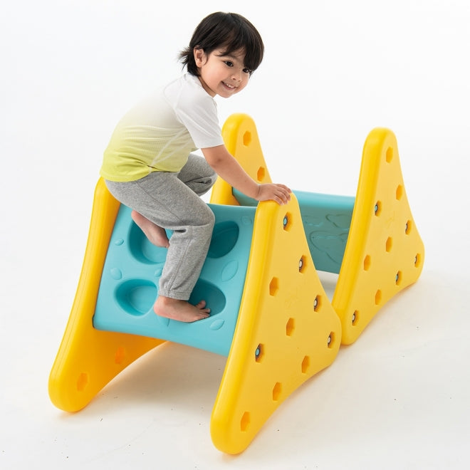 Weplay Over The Mountain climbing toy; child climbs yellow modular frames with turquoise ramp.