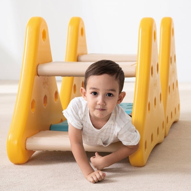 Weplay Over The Mountain activity climber in bright yellow plastic arches with beige steps; toddler crawls through.
