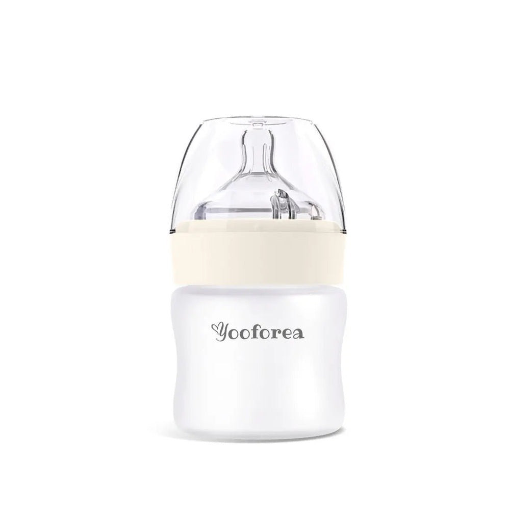 Yooforea Silicone Coated Glass Baby Bottle 3Oz/90Ml on white surface, beige collar and clear nipple top.