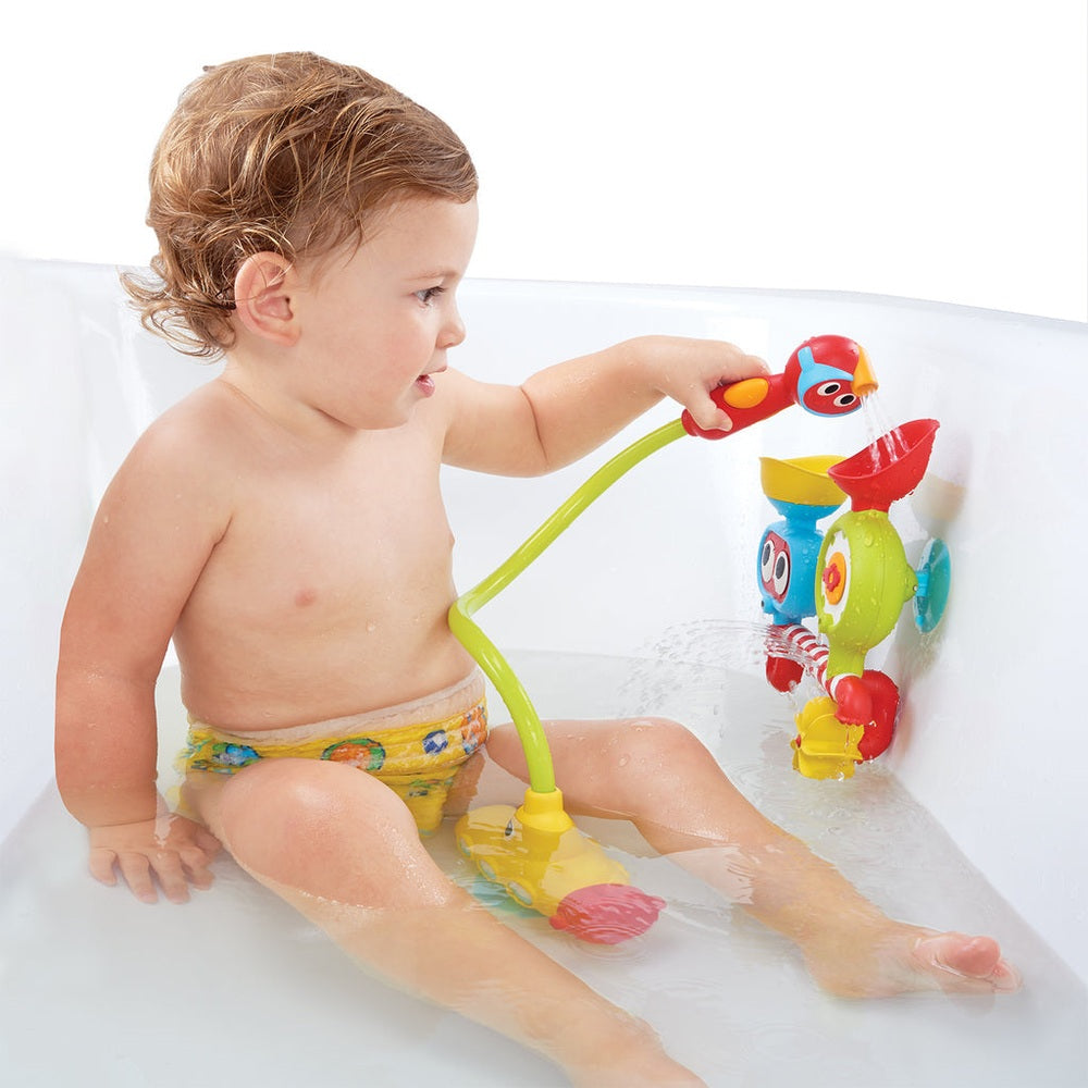 Yookidoo Submarine Spray Station bath toy; colorful plastic set with green hose, red and yellow accents, toddler in tub