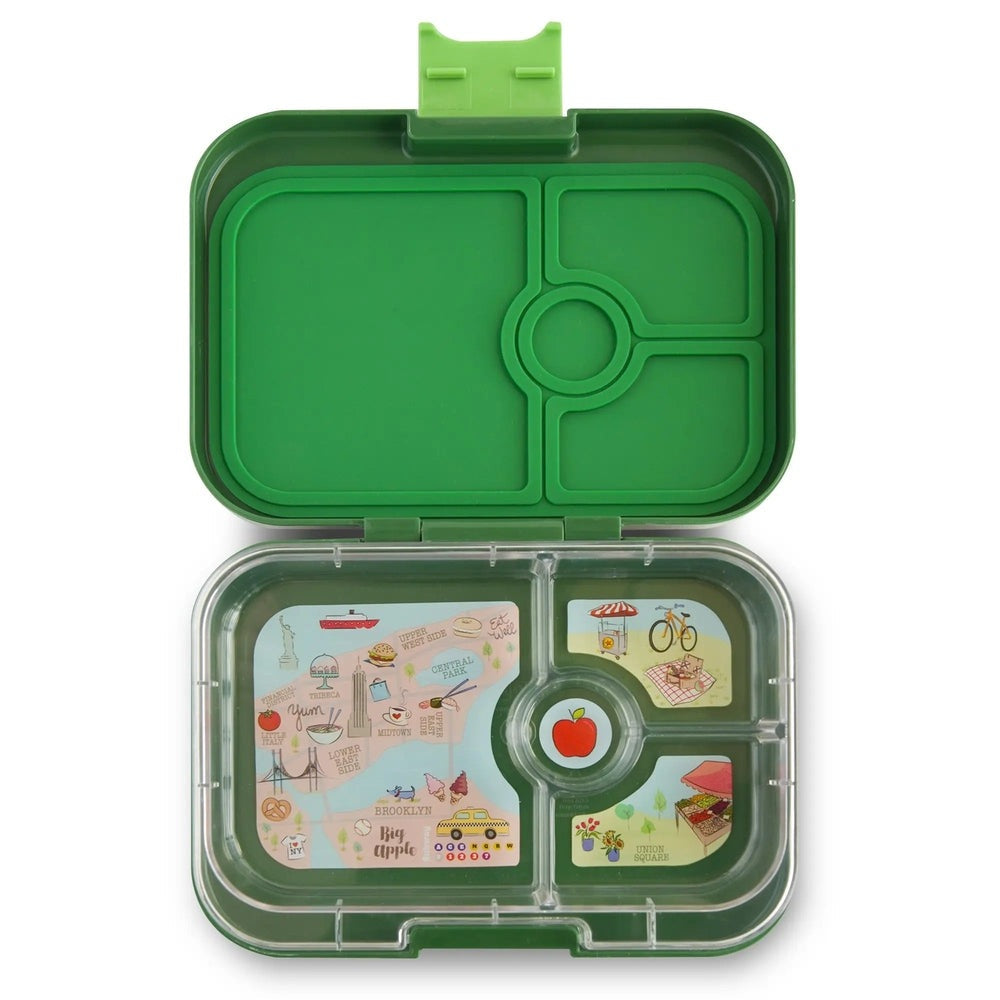 Yumbox Panino 4-compartment lunchbox open on green tray with illustrated inserts: apples and city map.