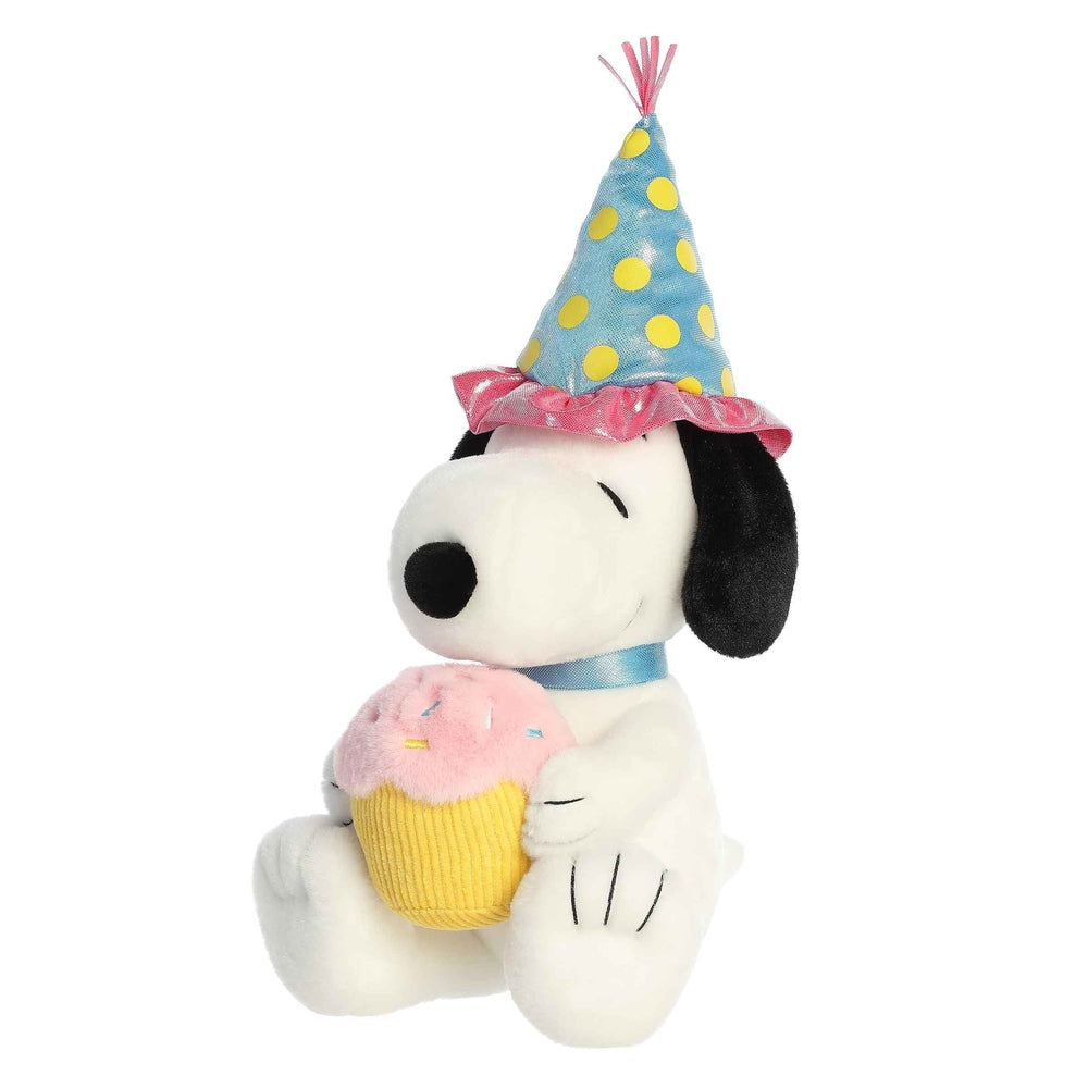 Aurora Snoopy birthday plush holding a cupcake, wearing a blue polka-dot party hat with pink frill