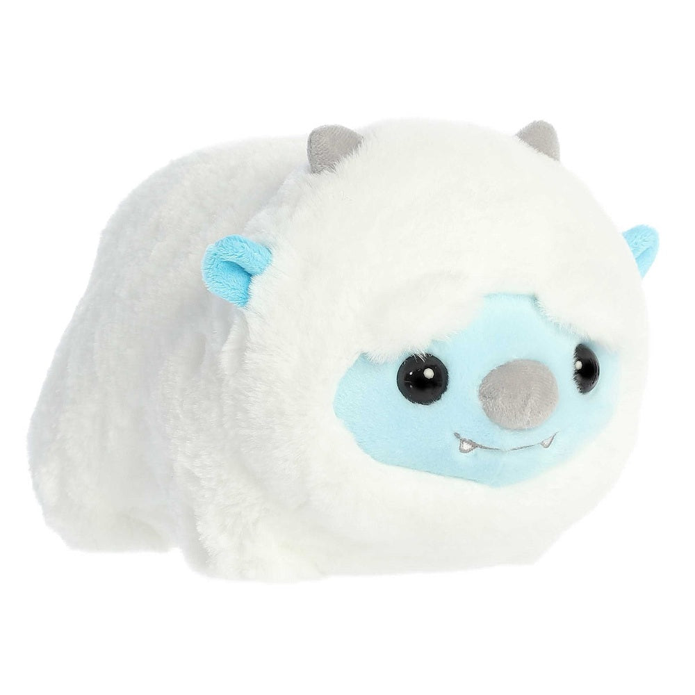 Aurora Spudsters Yanni Yeti 10" plush toy, fluffy white with a blue face, lying cuddly with big black eyes.