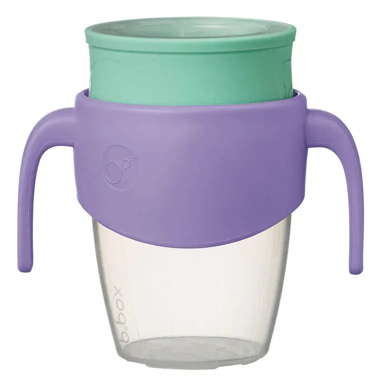 B.Box 360 Cup with lavender sleeve, mint lid, dual purple handles as a toddler grips and sips.