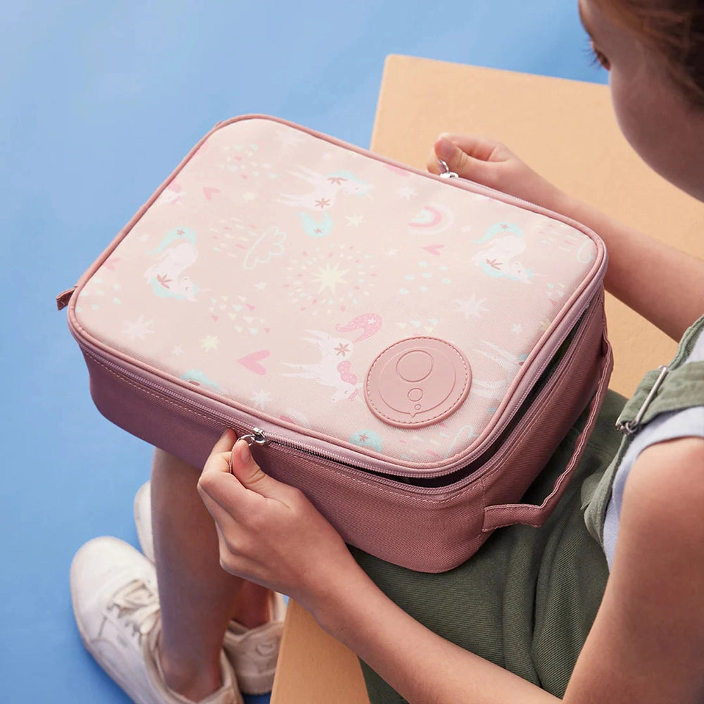 B.box Insulated Flexi Lunchbag in pink with whimsical print; child opens the zipper to access its insulated interior.