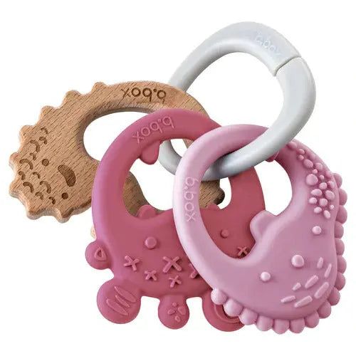 B.BOX Trio Teether set: three pink silicone teethers linked to a wooden ring for easy grasping.